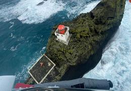 One member of the helicopter crew went down to Þrídrangar to check on the lighthouse and the situation there and the hoisted back up.