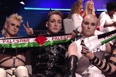 Hatari band members, waving a banner in the colors of the Palestinian flag.