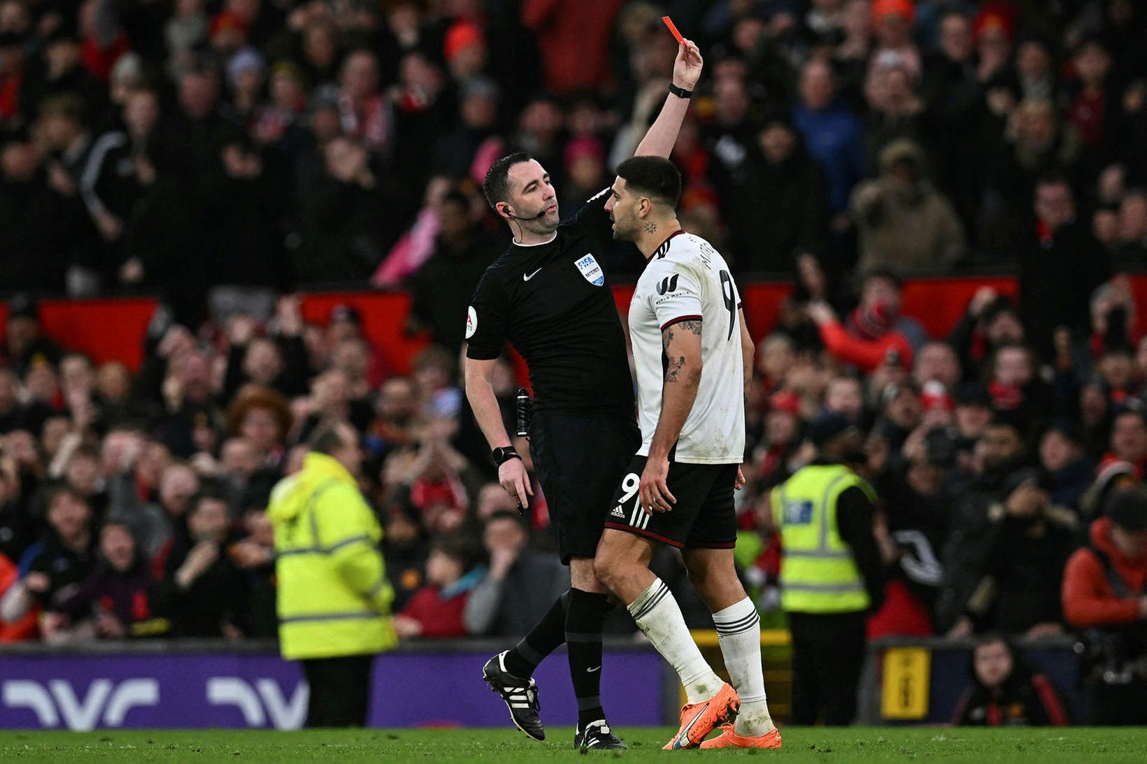 Aleksandar Mitrovic veitist að Chris Kavanagh á Old Trafford.