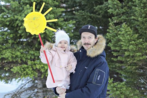 Father and daughter celebrate the sun coming up behind the mountains for the first time in 74 days.
